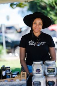 Entrepreneur showcasing handmade goods at a vibrant outdoor market.