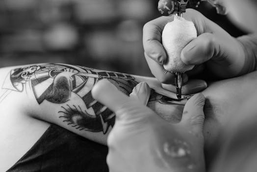 A tattoo artist working on a forearm tattoo in a tattoo parlor, showing intricate details.