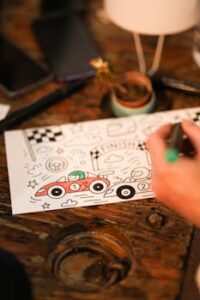 Artistic hand-drawn doodle of race cars and finish line on a wooden table, capturing creativity and focus.